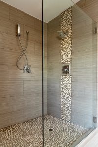 Contemporary shower showing dual shower heads and detail stone work. Also has glass enclosure.